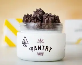 female hand grabbing an edible from a jar